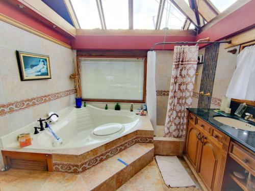 a large bathroom with a tub and a sink at Casa Guaymaral. Encantadora, rural y espaciosa in Bogotá