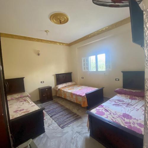 a room with two beds and two tables at Siwa star in Siwa