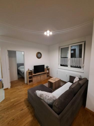 a living room with a couch and a television at Lux Advent Apartment in Subotica