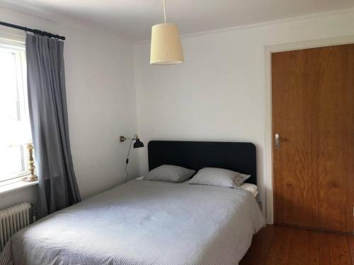a bedroom with a bed and a wooden door at Agunnaryd village holiday home - close to lake in Agunnaryd
