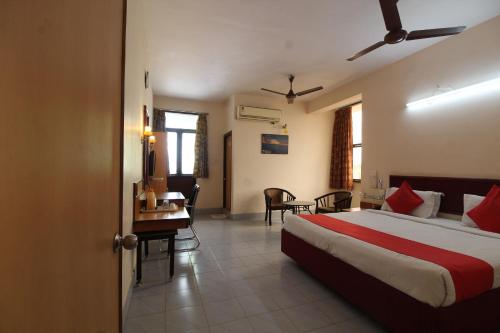 ein Schlafzimmer mit einem Bett und einem Schreibtisch in einem Zimmer in der Unterkunft Agarwal's Residency in Visakhapatnam