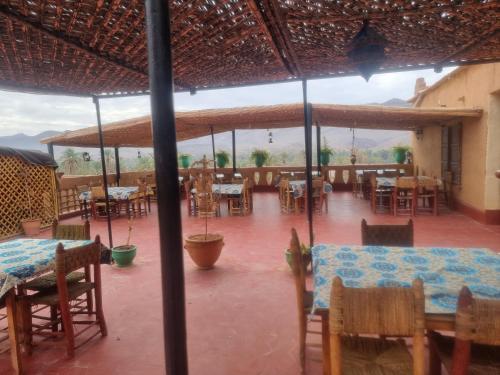 een restaurant met tafels en stoelen op een patio bij Chez Yacob Tamnougalt in Agdz