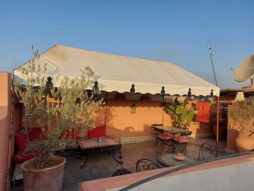 a patio with a tent with tables and potted plants at Riad Sophora - Peaceful Heaven in Marrakech in Marrakesh
