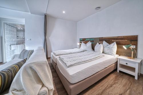 a bedroom with a large bed and a chair at Apartment Römerbrücke - Ponte Romano in Merano