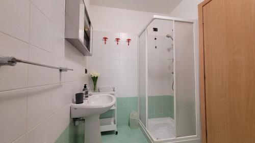 een badkamer met een wastafel en een douche bij La casa nel borgo Mountain Lake Iseo Hospitality in Bossico