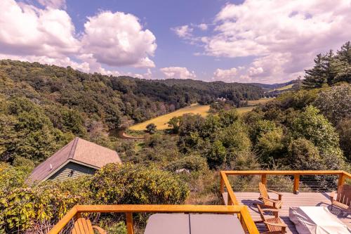 a view from the deck of a home with a view of the mountains at River View Retreat in Boone