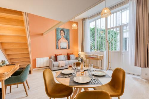 - un salon avec une table et des chaises dans l'établissement Maury - Luxury Loft - Heart of Montparnasse, à Paris