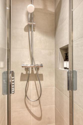 une douche avec une porte vitrée dans une salle de bain dans l'établissement Maury - Luxury Loft - Heart of Montparnasse, à Paris