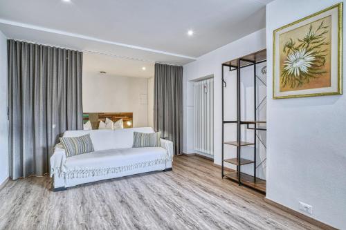un soggiorno con divano bianco in una camera di Apartment Römerbrücke - Ponte Romano a Merano