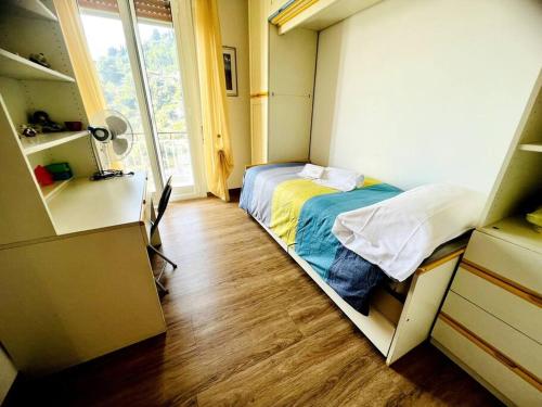 ein kleines Schlafzimmer mit einem Bett und einem Fenster in der Unterkunft Suite BBQ And Garden - Sanremo in Sanremo