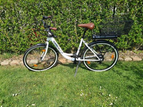 a bike with a basket parked in the grass at La Cantraigne gite de 6 à 8 pers. in Audembert