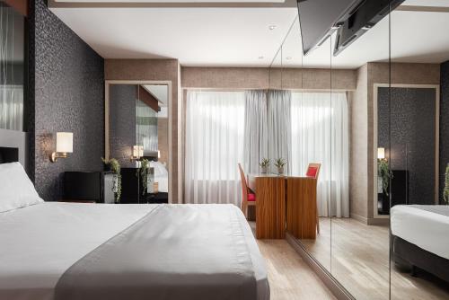 アテネにあるLacoba Hotelのベッドとデスクが備わるホテルルームです。