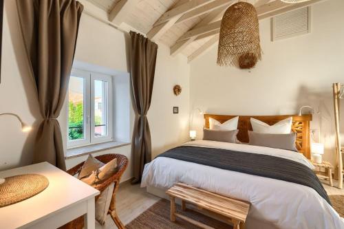 1 dormitorio con cama, mesa y ventana en Villa Vin with 2 bedrooms and pool in Porec, en Nova Vas