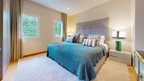 une chambre avec un lit avec une couverture bleue et une fenêtre dans l'établissement Villa White, à Saint-Tropez