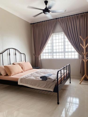 a bedroom with a bed with a ceiling fan at Seaview apartment in Kuala Terengganu