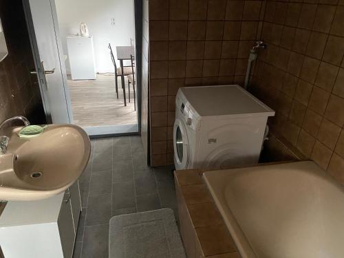 a bathroom with a sink and a washing machine at Zimmervermietung M.Simon in Ronnenberg