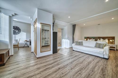 a large bedroom with a white bed and wooden floors at Apartment Römerbrücke - Ponte Romano in Merano