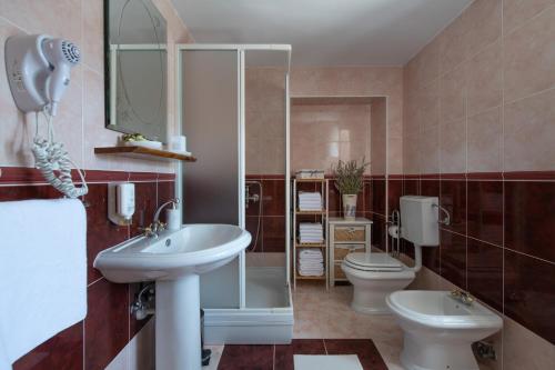 y baño con 2 aseos, lavamanos y espejo. en Villa Smolica en Krnica