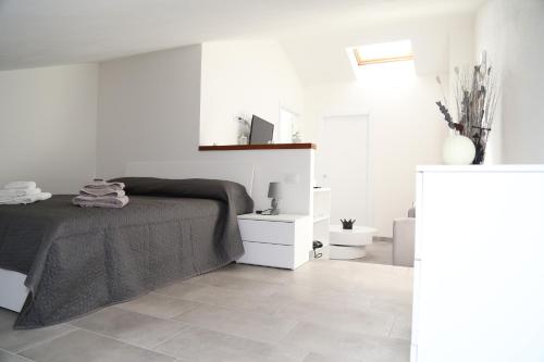 una camera bianca con letto e pavimento piastrellato di Al civico 5 - Mondern Apartments & Suite! a Decimomannu