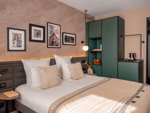 a bedroom with a large bed with a green cabinet at Novotel Orléans Centre Gare in Orléans