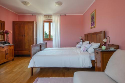 Habitación de color rosa con 2 camas y ventana en Villa Smolica en Krnica