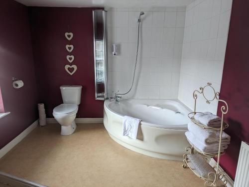 a bathroom with a white tub and a toilet at Charles Cotton Hotel in Hartington