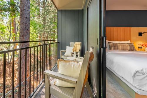 a bedroom with a balcony with a bed and a chair at The Incline Lodge in Incline Village