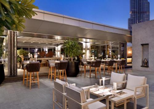 a restaurant with tables and chairs on a patio at EMAAR Residences Fashion Avenue - former Address Dubai Mall Residences by Qstay in Dubai