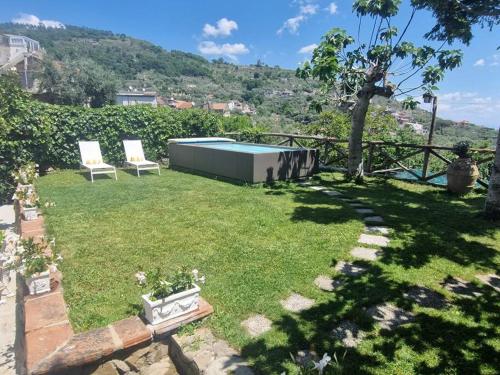 a yard with two chairs and a swimming pool at The Retreat Rustic Charm, Views & Pool by Feeling Italy in Massa Lubrense