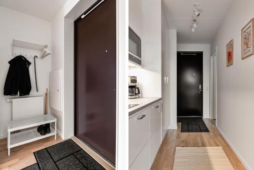 a kitchen with white cabinets and a brown door at Cosy Urban Home in Stockholm in Stockholm