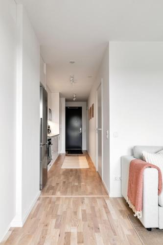 a hallway with white walls and a hard wood floor at Cosy Urban Home in Stockholm in Stockholm