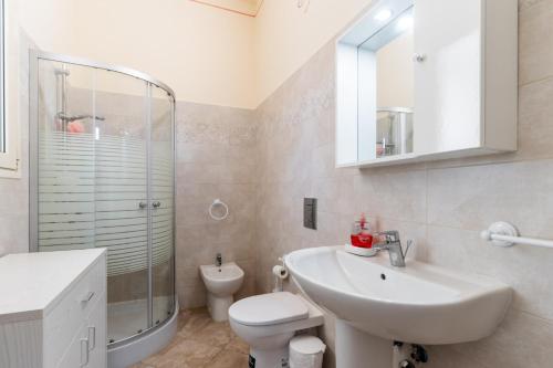 een badkamer met een wastafel, een toilet en een douche bij Appartamento Verde 1 in Castrignano del Capo