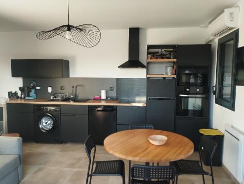 een keuken en eetkamer met een tafel en stoelen bij Beau logement neuf à 5 mn de la mer in Ventiseri