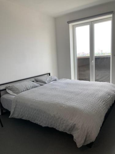 a white bedroom with a bed and a window at CASA DE' COLE' in Barking