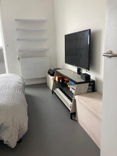 een slaapkamer met een tv en een toetsenbord en een bed bij CASA DE' COLE' in Barking
