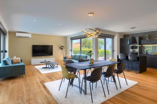 a dining room and living room with a table and chairs at Luxury villa Hedone with pool in Rakalj in Rakalj