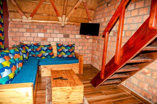 a living room with a blue couch and a wooden table at Masaka Cultural Resort in Masaka