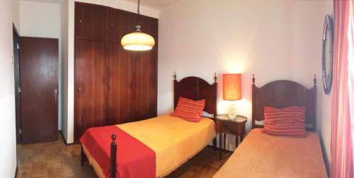 SilveiraにあるSanta Cruzのベッドルーム1室(オレンジと赤の枕が備わるベッド2台付)