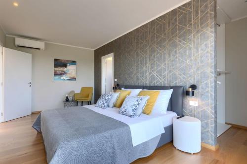 a bedroom with a large bed and a wall at Luxury villa Hedone with pool in Rakalj in Rakalj