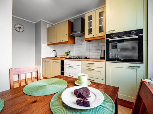 a kitchen with a table with a plate of cake on it at Gdynia Wyjątkowy Apartament przy Lesie by Renters in Gdynia