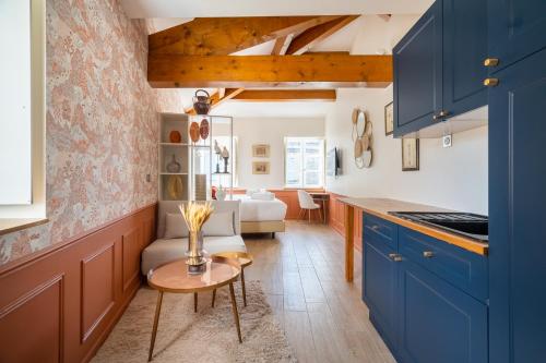 a kitchen with blue cabinets and a table at La Réserve de Salon de Provence in Salon-de-Provence