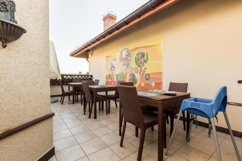 a patio with tables and chairs and a painting on the wall at Hotel Krzyski in Tarnów