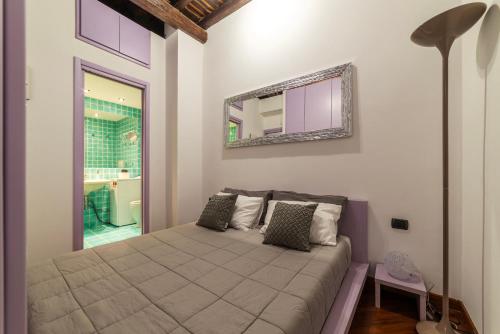 een slaapkamer met een groot bed met een spiegel aan de muur bij Lovely Apartment ad un passo da Piazza del Popolo! in Rome