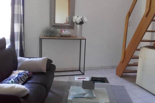 uma sala de estar com um sofá e uma mesa de vidro em locmiquélic petite maison de pêcheur em Locmiquélic