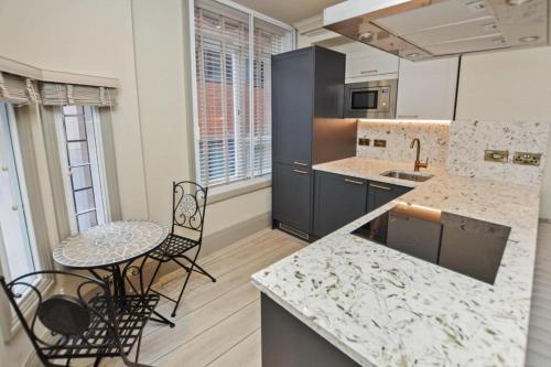 a kitchen with a counter and a table and chairs at Stylish En-suite in the heart of Manchester in Manchester