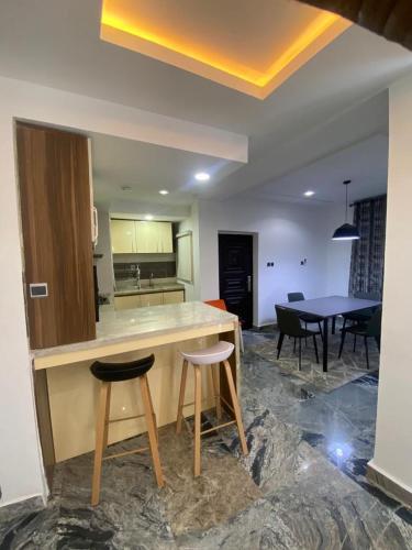 a kitchen with two stools and a counter and a table at Dazzle hotels and apartments in Abuja