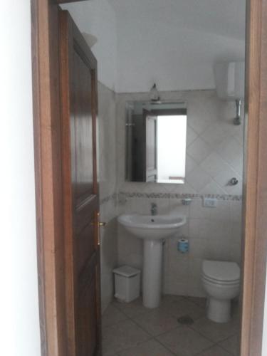 a bathroom with a sink and a toilet and a window at Agriturismo La Mancosa in Pollica
