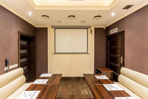 a room with two tables and a projection screen at Hotel Krzyski in Tarnów