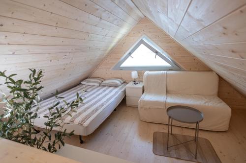a small attic bedroom with a bed and a window at Nadmorska Perełka in Rusinowo