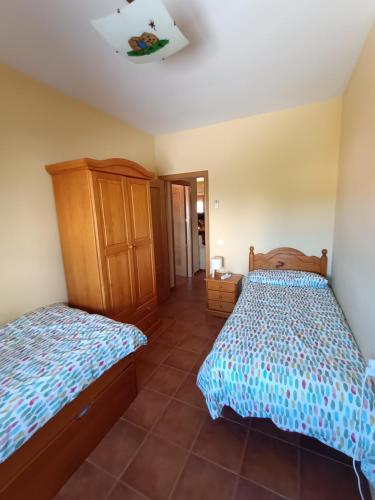 a bedroom with two beds and a cabinet at El rincon de los enebros in Ruidera